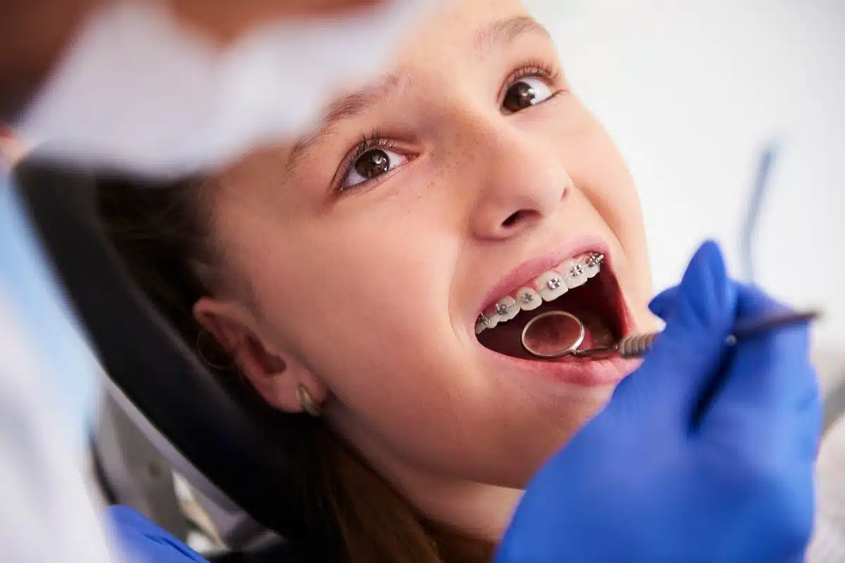 orthodontic admin support ensures a smooth workflow for specialty practices, allowing clinicians to focus on intricate tasks like adjusting braces for this young patient during a routine checkup.